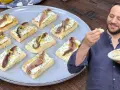 Deliziosi crostini con acciughe e robiola, guarniti con scorza di limone, pronti per essere gustati.