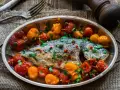 Orata all'acqua pazza, un piatto saporito con pomodorini, capperi e prezzemolo, pronto per essere gustato.