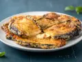 Melanzane contorno dorate e filanti, un piatto invitante con formaggio fuso e basilico fresco.