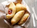 Panzerotti pugliesi dorati e fragranti, uno aperto rivela un ripieno succulento.