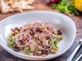 Deliziosa insalata di ceci e tonno con olive nere, cipolla rossa e prezzemolo fresco. Un piatto leggero e gustoso.