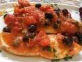 Delizioso pesce spada al forno con pomodorini, olive nere e capperi, un piatto saporito e colorato.