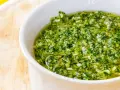 Una ciotola bianca piena di vibrante salsa verde, perfetta per accompagnare i tuoi piatti. Questa ricetta salsa verde è un'esplosione di freschezza.
