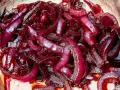 Cipolla rossa caramellata, lucida e succosa, pronta per arricchire ogni piatto con il suo sapore dolce e intenso.