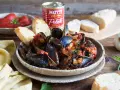Piatto fumante di cozze alla tarantina ricetta, con pane tostato e pomodori pelati Mutti.