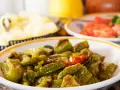Un piatto di peperonata ricetta della nonna, con peperoni verdi e qualche pomodoro, cotta lentamente per un sapore autentico.