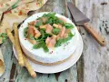 Deliziosa cheesecake salata con salmone affumicato, rucola e crostini. Perfetta per un aperitivo o antipasto elegante.