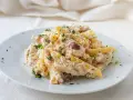 Piatto di pasta cremosa con tonno, olive nere e capperi, guarnita con prezzemolo fresco. Un classico della pasta tonno e olive.