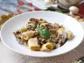 Piatto invitante di pasta panna e funghi, guarnito con basilico fresco.