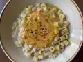 Un piatto di pasta e fagioli estiva, con ditalini e fagioli cannellini, guarnito con una purea di verdure e peperoncino.
