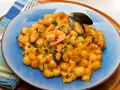 Gnocchi di patate con frutti di mare, gamberi e cozze, guarniti con prezzemolo fresco.