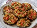 Fette di melanzane ripiene in friggitrice ad aria, condite con pomodorini e pangrattato, pronte per essere gustate.