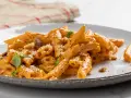 Penne con una ricca crema di peperoni, guarnite con basilico fresco e crostini croccanti. Un piatto invitante e saporito.