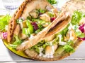 Pita ripiena di pollo e insalata fresca, condita con una cremosa salsa yogurt.