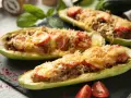 Zucchine tonde ripiene, un piatto gustoso con carne macinata, pomodoro e formaggio fuso, pronto per essere gustato.