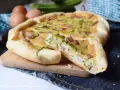 Torta salata con zucchine e pancetta, una fetta tagliata mostra il ripieno gustoso. Ingredienti freschi e profumati.