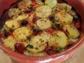 Piatto di riso patate e cozze cotto al forno, con pomodorini e erbe aromatiche, servito in una terrina di terracotta.