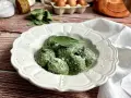 Gnudi verdi, una deliziosa ricetta con spinaci e ricotta, guarniti con parmigiano e una foglia di salvia.
