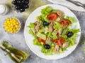 Deliziosa insalata di tonno con lattuga croccante, pomodoro, mais e olive nere. Un piatto fresco e leggero, perfetto per ogni occasione.