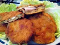 Cordon bleu di melanzane impanati e fritti, ripieni di prosciutto e formaggio filante, serviti su un letto di lattuga croccante.
