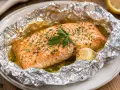 Succulento salmone al cartoccio, cotto con aglio e prezzemolo, pronto per essere gustato.