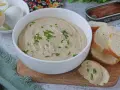 Una cremosa salsa tonnata con maionese, guarnita con erba cipollina, pronta per essere gustata con pane tostato e uova sode.