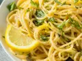 Spaghetti al limone, un classico della ricetta della Costiera Amalfitana, guarniti con scorza di limone e basilico fresco.
