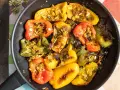 Peperoni ammollicati cotti in padella, ripieni di pangrattato e erbe aromatiche, con colori vivaci.