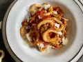 Un piatto di anellini alla pecorara, pasta a forma di anello condita con sugo di pomodoro, verdure e scaglie di formaggio.