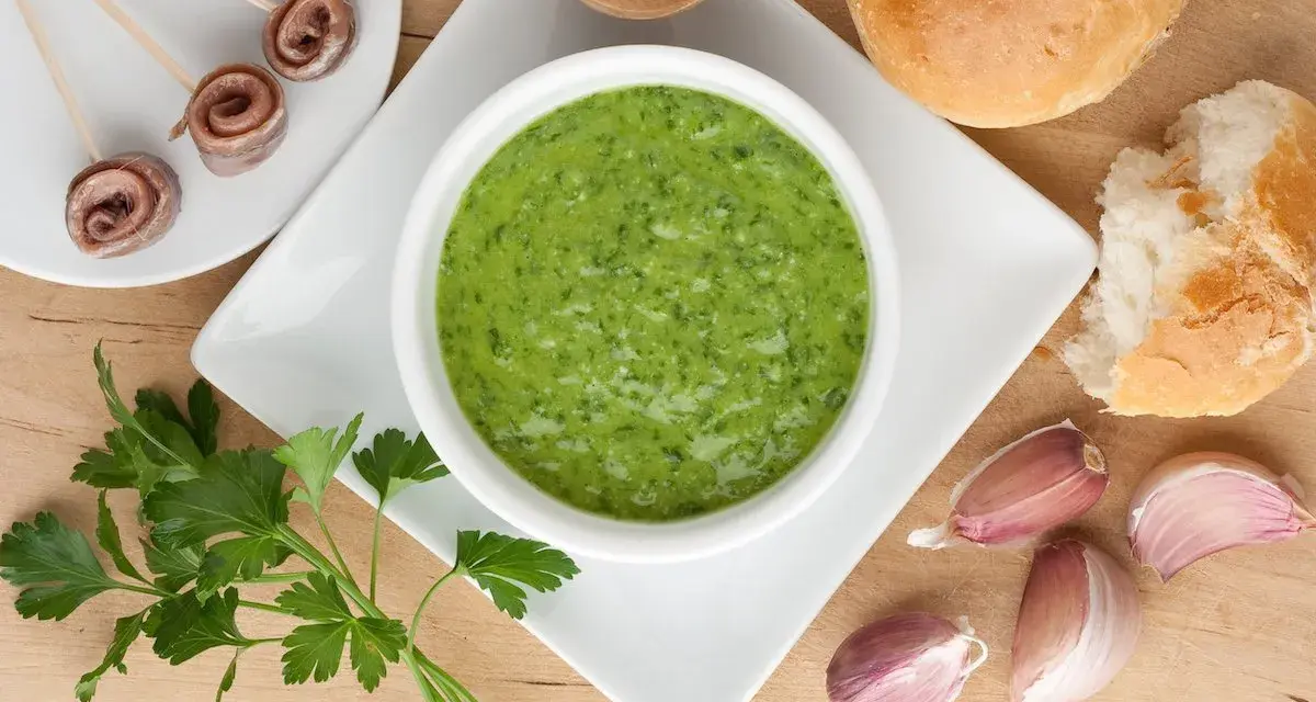 La salsa verde ricetta della nonna, con prezzemolo fresco, aglio e acciughe, pronta per essere gustata con pane croccante.