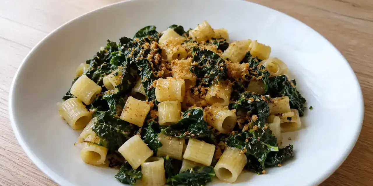Piatto di pasta con cavolo nero e acciughe, condita con pangrattato croccante.