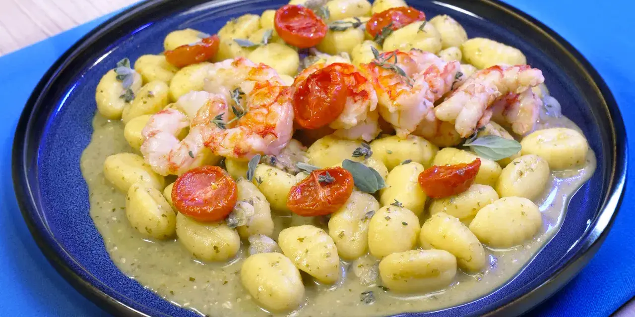 Gnocchi con pesto, gamberi succulenti e pomodorini confit. Un piatto che celebra i sapori del mare e della terra.