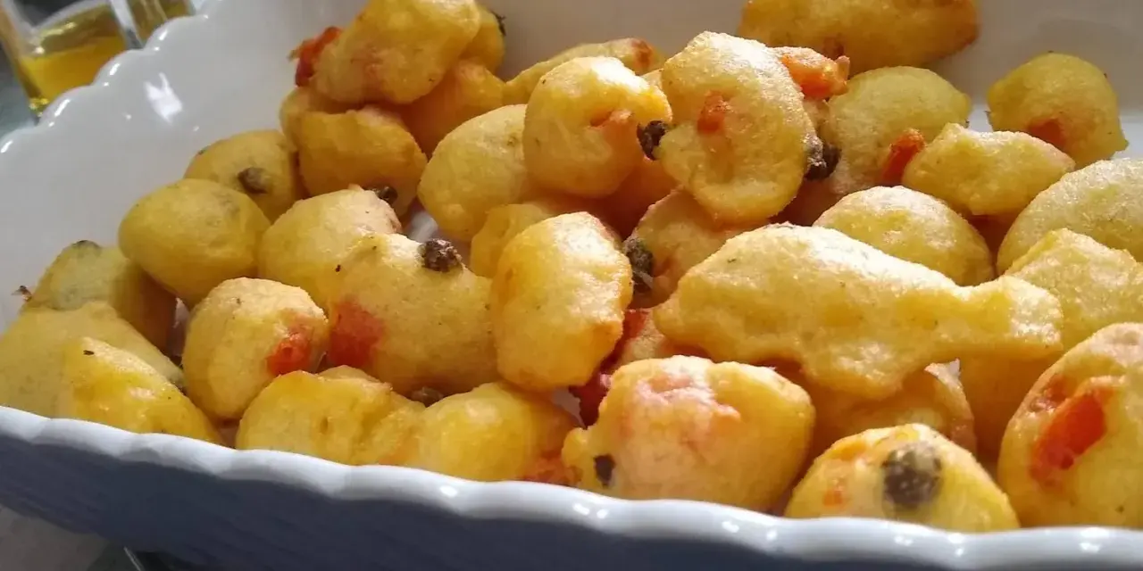 Pittule salentine dorate e fragranti, un tripudio di sapori pugliesi in un piatto.