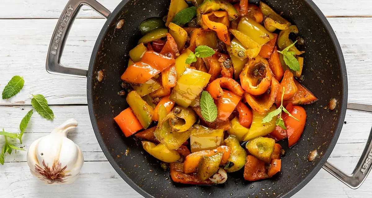 Peperoni in padella, colorati e succosi, cotti con aglio e menta. Un contorno saporito e facile da preparare.