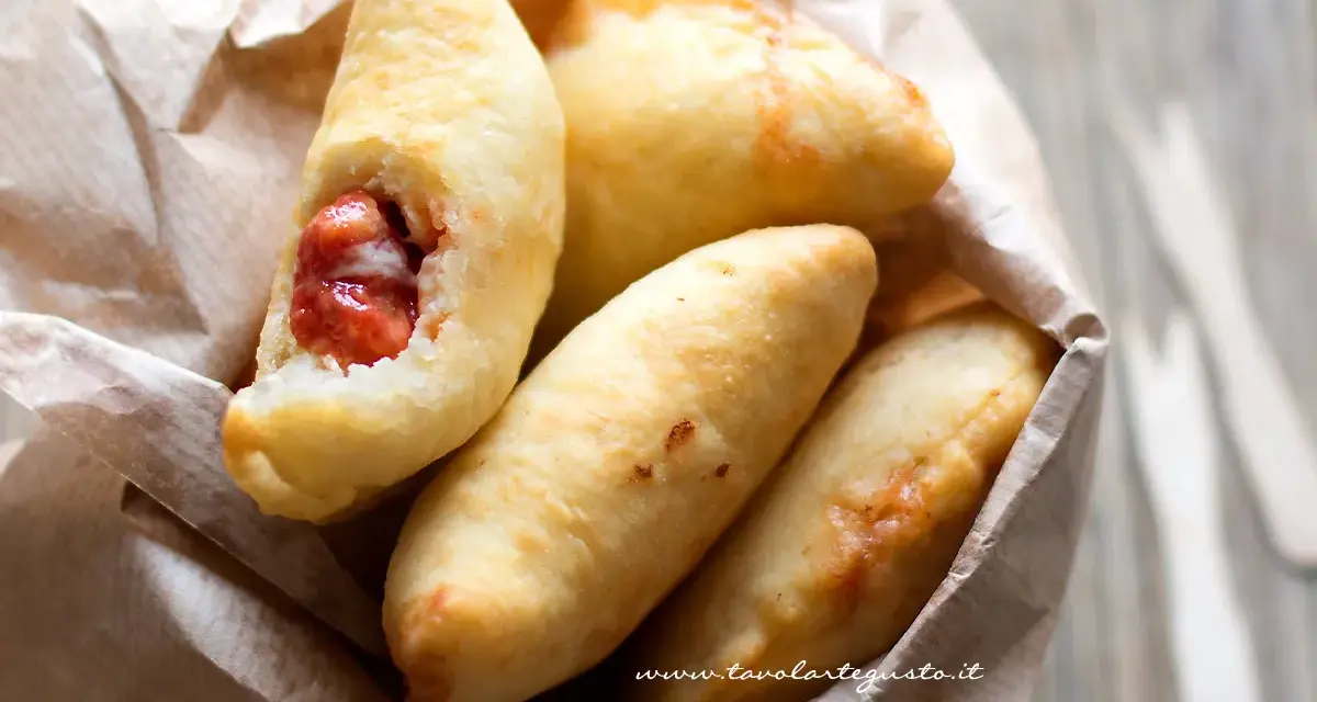 Panzerotti pugliesi dorati e fragranti, uno aperto rivela un ripieno succulento.