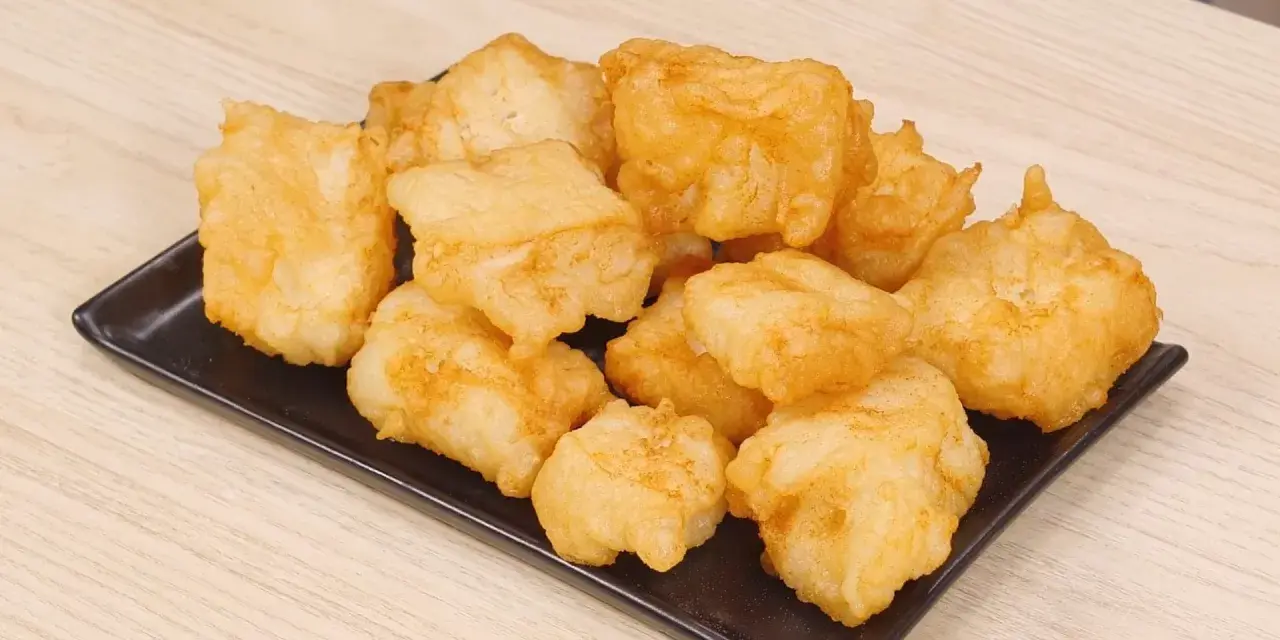 Un piatto di invitante baccalà fritto, dorato e croccante, pronto per essere gustato.