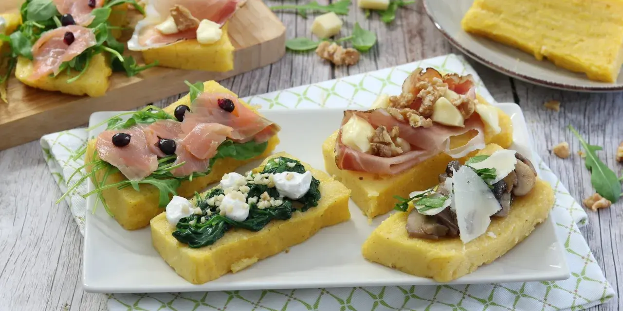 Deliziosi crostini di polenta misti: con salmone affumicato, spinaci e ricotta, prosciutto e noci, o funghi e parmigiano.