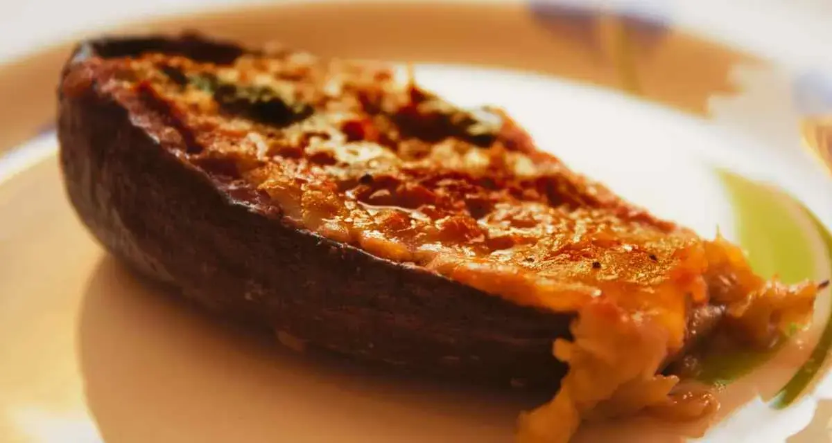 Melanzane ripiene calabresi, un piatto saporito con un ripieno dorato e filante, pronto per essere gustato.