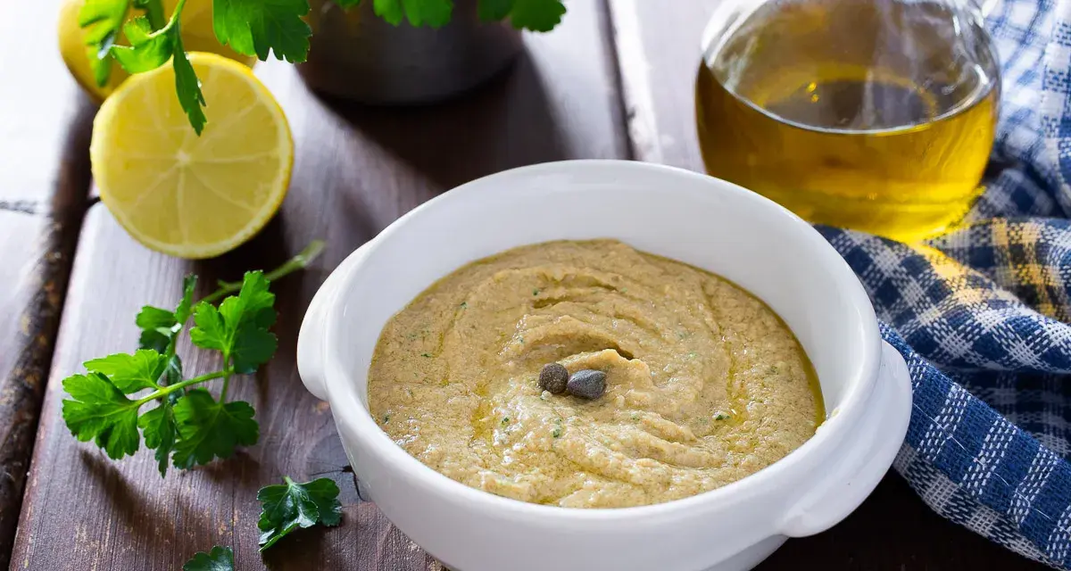 Una cremosa salsa tonnata con uova sode, guarnita con capperi, pronta per essere gustata.