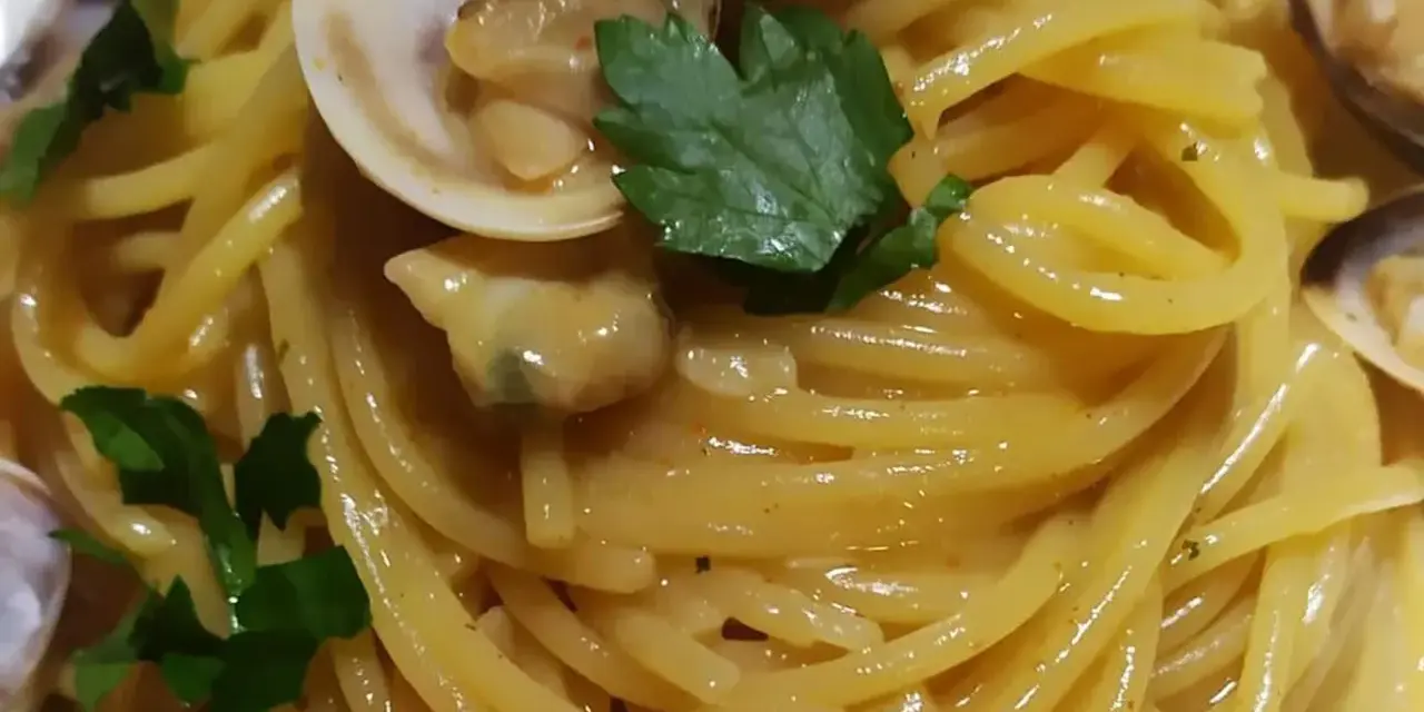 Spaghetti alle vongole cremosi come al ristorante, un piatto invitante con vongole fresche e prezzemolo.
