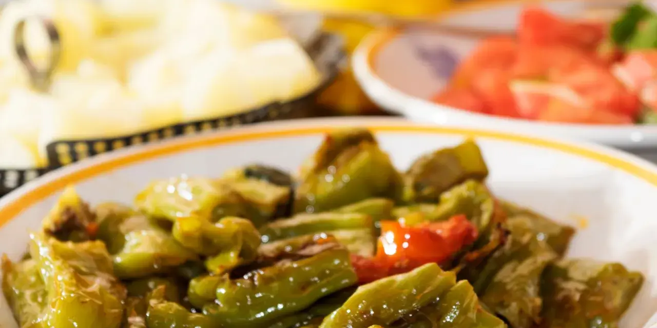 Un piatto di peperonata ricetta della nonna, con peperoni verdi e qualche pomodoro, cotta lentamente per un sapore autentico.