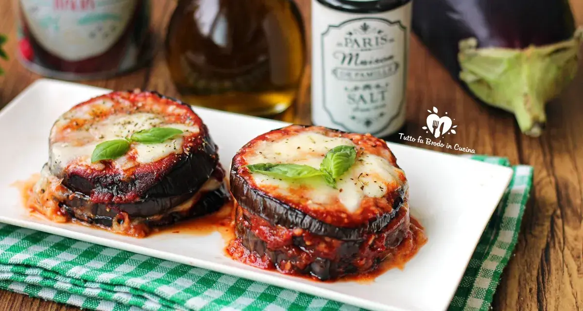 Deliziosa parmigiana di melanzane grigliate, con strati di melanzane, sugo e formaggio filante, guarnita con basilico fresco.