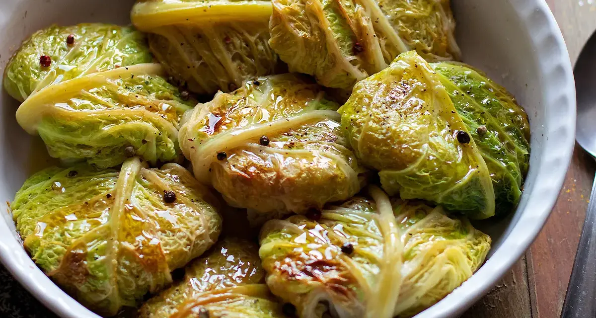Verza ripiena in teglia, condita con olio e pepe nero. Un piatto confortante e saporito, pronto per essere gustato.