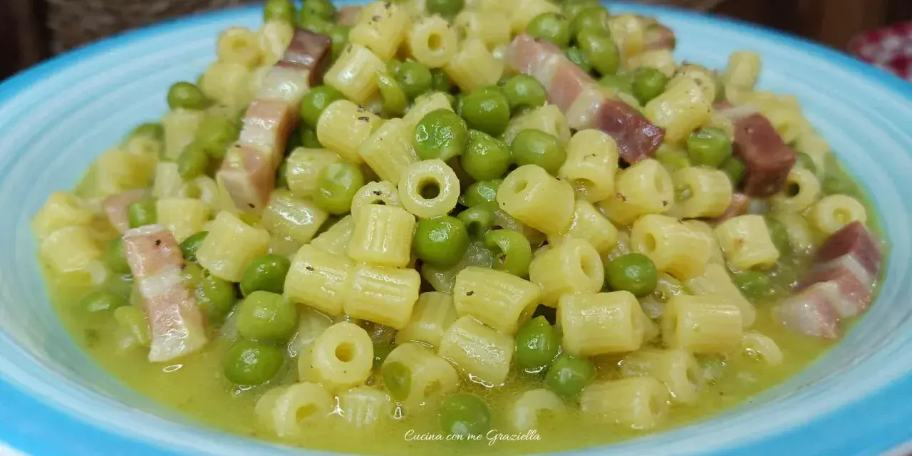 Un piatto invitante di pasta e piselli con cubetti di pancetta croccante, condito con una salsa cremosa.