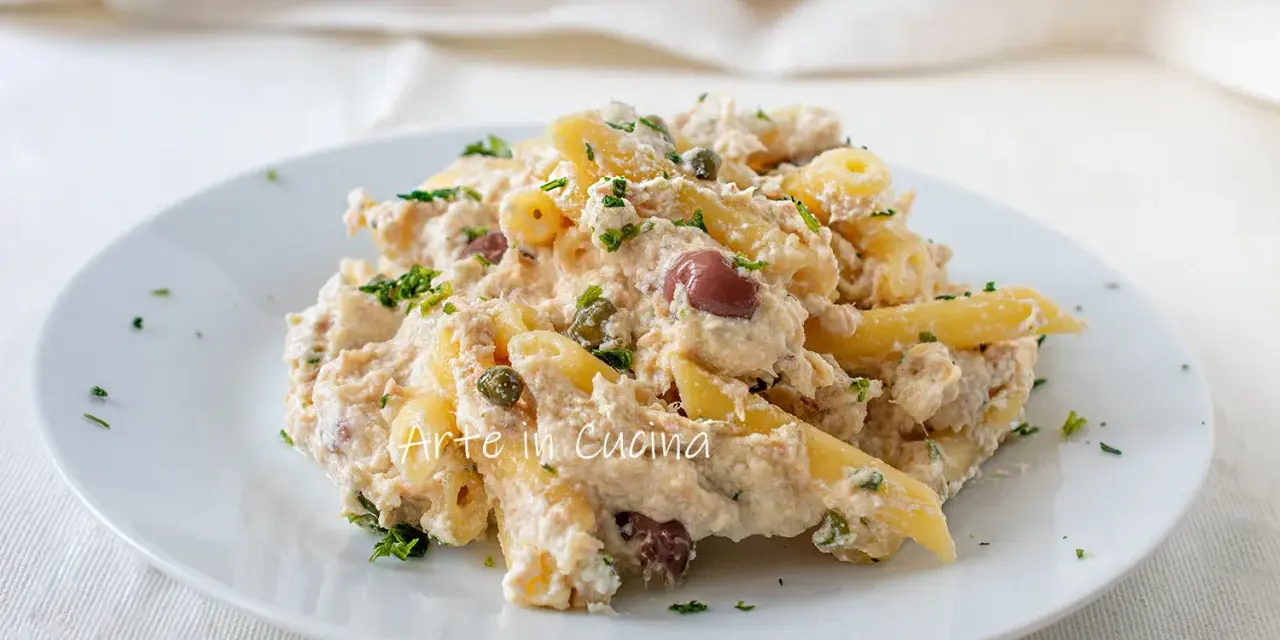 Piatto di pasta cremosa con tonno, olive nere e capperi, guarnita con prezzemolo fresco. Un classico della pasta tonno e olive.