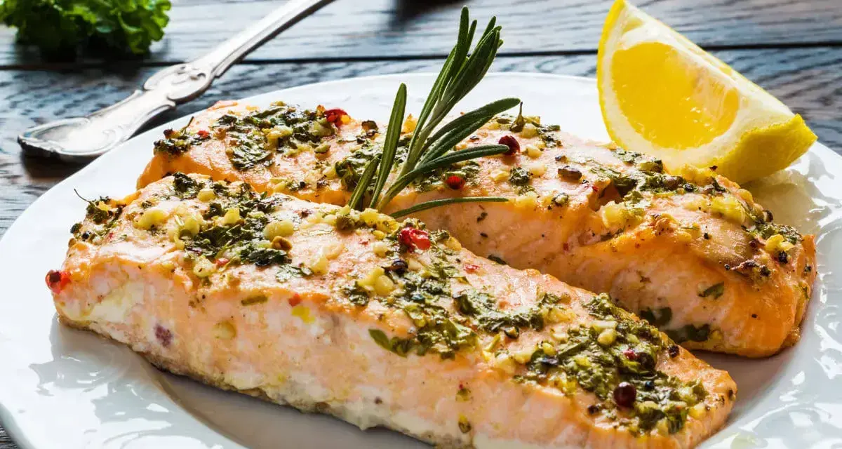 Delizioso salmone al forno con erbe aromatiche, aglio e un tocco di limone, pronto per essere gustato.