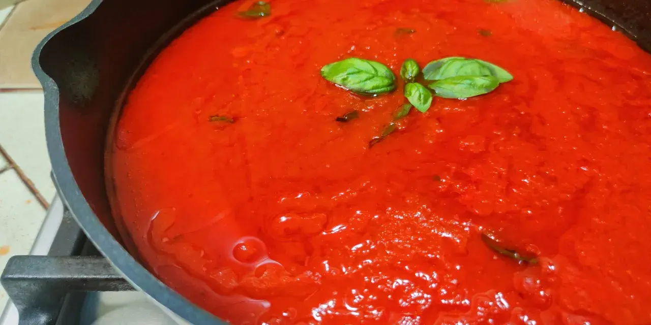 Sugo di pomodoro fresco in padella, profumato con basilico. La ricetta della nonna per un sapore autentico.