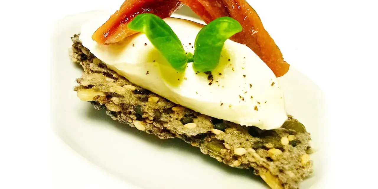 Crostini con burrata cremosa, alici del Cantabrico e basilico fresco. Un boccone di puro piacere.