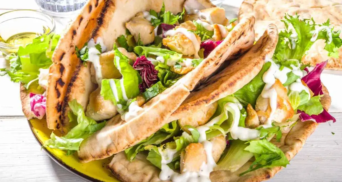 Pita ripiena di pollo e insalata fresca, condita con una cremosa salsa yogurt.