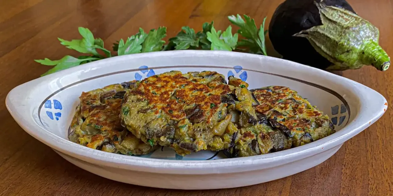 Tre deliziosi hamburger di melanzane dorati, guarniti con prezzemolo fresco, in un piatto rustico.